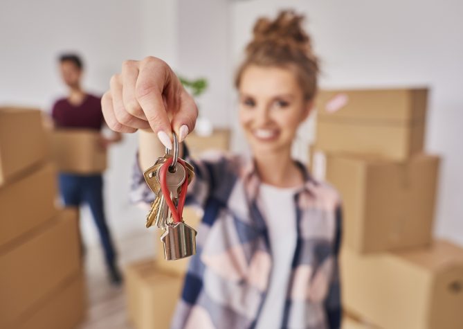 Woman's hand showing keys from new apartment