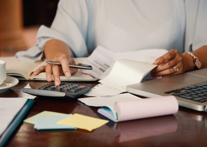 Hands of female entrepreneur working with bills and documents