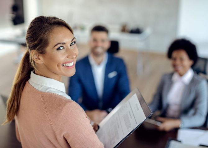 Happy woman applying for job in the office and looking at the camera.