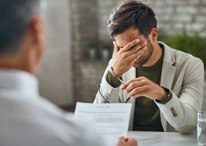 Worried male candidate having a job interview with a manager in the office.