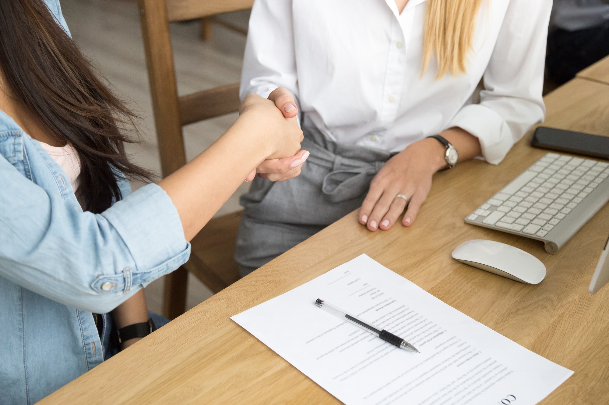 Two women partners handshaking after signing business contract at meeting, female client or customer and manager agent broker closing good deal, female hands shaking making agreement, close up view