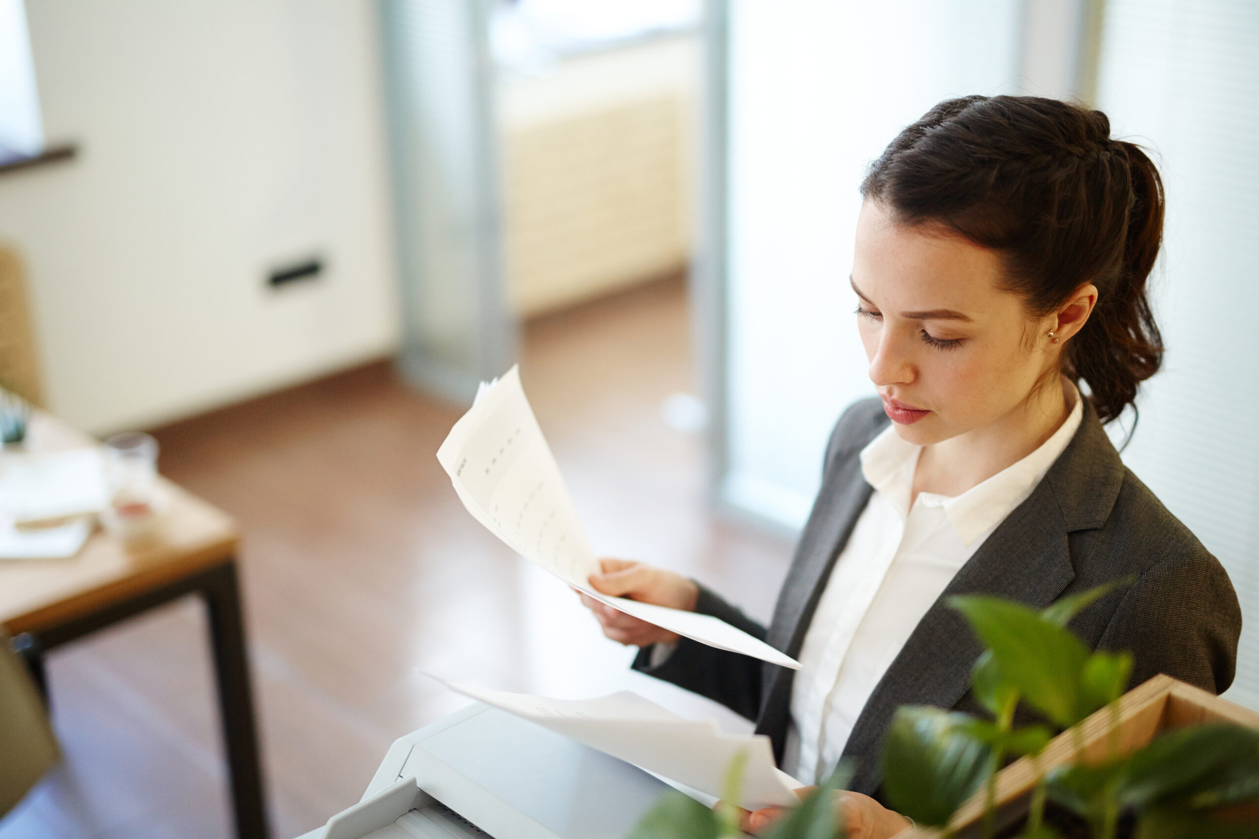 Young manager reading business papers or contracts in office